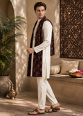 Man wearing a traditional outfit with a vest in an outdoor setting